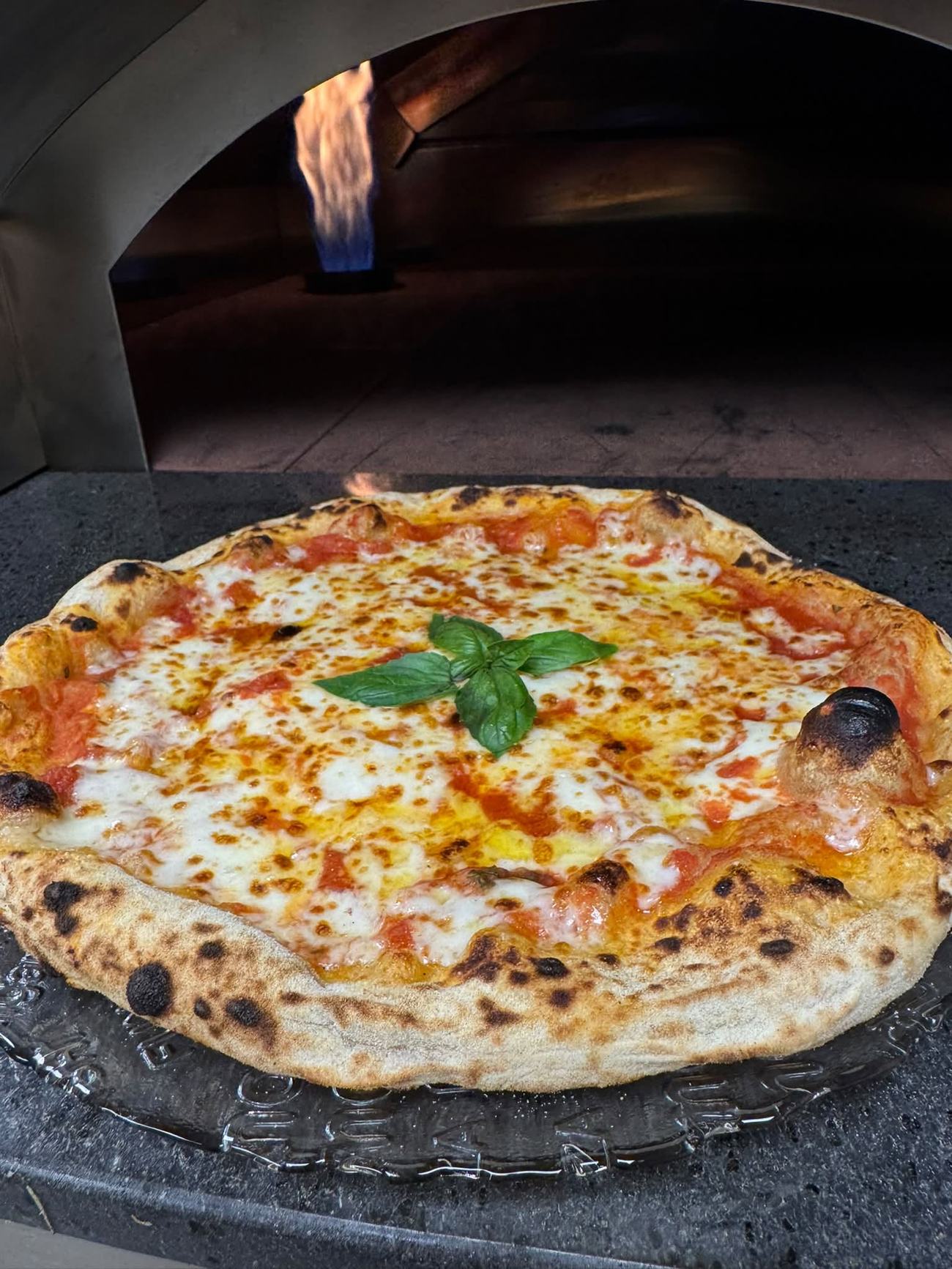 Pizza margherita sortant du four à bois